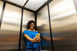 © Raymond Forbes LLC/Stocksy - Black Girl on cell phone travel elevator fashion