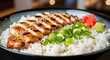 © Rashid Ansari - Teriyaki chicken slices rest on a bed of white rice with green onions and ginger in a ceramic bowl.