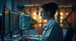 © Yassine - Focused female engineer programming advanced robotics software on multiple computer monitors inside a modern industrial facility