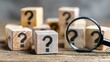 © Momin Photo Gallery - Wooden blocks with question marks and magnifying glass for problem solving