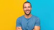 © Anmoy - Smiling young man with stubble and crossed arms on a vibrant yellow and blue background Wallpaper Background image