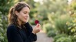 © studio - Young woman holding a red flower petal in a peaceful garden setting