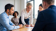 © Athena Studio - Focused blonde businesswoman signing official documents while sitting at a meeting table with colleagues.