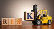 © Hammad - Risk management and assessment concept. Forklift moving a block with letter K. Business strategy and logistics.