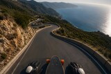 Aerial perspective over coastal mountain trail winding asphalt road used for downhill longboarding skateboarding sports