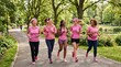 © Felippe Lopes - Diverse group of women of different ages and ethnicities running together in a park wearing pink sportswear for breast cancer awareness