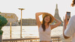 © blueringmedia - Young Woman Posing for Smartphone Photo by Wat Arun at Sunset