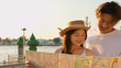 © blueringmedia - Young Asian Couple Reading Paper Map by Bangkok Riverside at Sunset