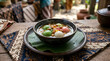 © wirda - Traditional indonesian wedang ronde ginger soup served in a rustic ceramic bowl with colorful rice balls and crunchy roasted peanuts