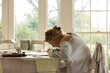 © Marc Romanelli - young woman artist using laptop as reference as she does a drawing in her studio