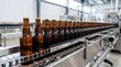 © Tina - A production line with brown glass beer bottles moving along a conveyor belt in a brewery. The setting is industrial and well-lit.