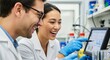 © Platon - A close-up shot of a male and female lab researcher in white coats smiling excitedly as they point at a digital monitor
