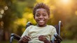 © Dream Studio - Close up portrait of a smiling young african american boy sitting in a wheelchair outside in a sunny green park