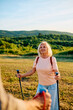 © we.bond.creations - Happy senior woman with trekking poles enjoying Nordic walking activity in nature, staying active and healthy in retirement