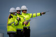© ADD PHOTO - Construction worker safety hard hat high visibility radio inspection site supervisor team coordinate field operation, pointing direction while holding tablet under clear sky