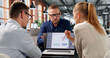 © Andrey Popov - Compliance Manager Leads Diverse Team Reviewing Risk Data Dashboard