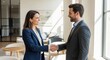 © Chainarong - Professional woman in a tailored suit shaking hands with a colleague in a bright modern office setting for a successful business deal