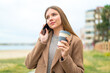 © luismolinero - Young pretty blonde woman using mobile phone and holding a coffee