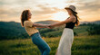 © CinematicStocks - Two young women spinning and holding hands at sunset