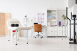 © Pixel-Shot - Modern physical therapy and rehabilitation clinic interior with medical equipment and anatomical skeleton model, the room includes a massage table with a foam roller