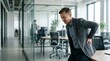 © Eve - Mature businessman suffering from acute back pain while standing in modern office health problems at work ergonomics sedentary lifestyle spinal injury spinal cord ache concept