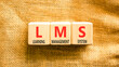 © Dzmitry - LMS learning management system symbol. Concept words LMS learning management system on beautiful wooden blocks. Beautiful canvas background. Business LMS learning management system concept. Copy space