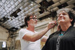 © Luciano Spinelli/Stocksy - Hairdresser cutting hair at industrial spaceship