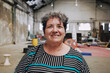 © Luciano Spinelli/Stocksy - Woman Smiles in a Spacious loft Workshop