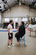 © Luciano Spinelli/Stocksy - Hairdresser Talks With client in Workshop
