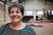 © Luciano Spinelli/Stocksy - Portrait of a smiling woman in an Industrial Space