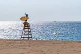 Lifeguard surveying ocean from tower on beach