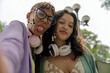 © Guillermo Spelucin - Diverse young friends taking playful selfie outdoors