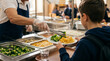 © Nusrat - Professional food service worker helping student select healthy meal in school lunchroom with variety of fresh vegetables and mac and cheese on plate during busy cafeteria service.