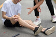 © jojo - The young man in the white shirt had suffered leg and knee injuries and had fallen to the ground, sitting down and clutching his knees with both hands in agony.
