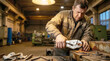 © Elena - Male worker focused on repairing mechanical part in workshop with tools in background