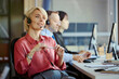 © DragonImages - Medium shot of Caucasian young adult woman wearing headset, assisting customers in call center office with team support. Ideal for customer service, CRM, outsourcing marketing