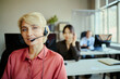 © DragonImages - Portrait of smiling Caucasian young adult woman wearing headset and assisting customers in call center office, representing client support and team service for business marketing