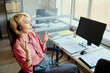 © DragonImages - Young adult Caucasian female operator wearing headset, speaking with client and gesturing at desk in call center office. Ideal for customer support, CRM, service team marketing