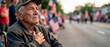 © Kristelinmind - Elderly man veteran with tear in eye hand on heart looking at parade during independence day. Patriotic American retired soldier feeling emotion at memorial event. Respect and pride.