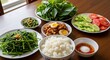 © Wellington - A bountiful spread of home-cooked Vietnamese cuisine features fluffy white rice, stir-fried water spinach, savory braised pork with egg, fresh cucumber and tomato slices, and a side of pickled greens.