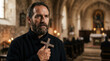 © Faith Stock Studio - Portrait of a bearded priest holding a wooden cross in a church. Religious figure in prayer inside a cathedral