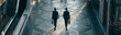 © pattozher - Brothers in Business: Two businessmen in silhouette walk purposefully down a modern hallway, their briefcases in hand, symbolizing ambition and the corporate journey.