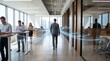 © Nest - Professional businessman walking through modern office corridor with glowing digital network lines connecting colleagues working at standing desks to show business connectivity