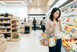 © maaagram - スーパーで野菜の値段を見て悩む日本人女性 Generative AI
