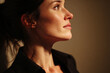 © Aurora Visual Lab - Confident businesswoman side profile looking toward future opportunities in warm dramatic indoor lighting