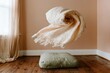© Ryzhkov - A folded cream linen blanket floating in a surreal spiral over a sage floor cushion in a quiet, airy room for wellness and lifestyle brands