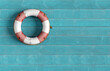 © Cagkan - Lifebuoy hanging on blue wooden wall offering safety