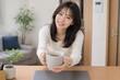 © AiPhoto - カフェで両手にカップを持つ女性