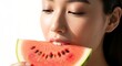 © harjiyo - Woman eating watermelon slice smiling.