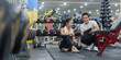 © Natee Meepian - Asian personal trainer discussing fitness workout plan with woman client in modern gym for healthy lifestyle